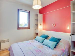 a bedroom with a bed and a red wall at Apartment Fleur Marine-9 by Interhome in Cabourg