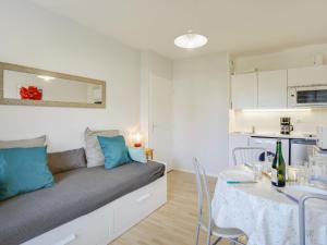 un soggiorno con divano e tavolo di Apartment Fleur Marine-9 by Interhome a Cabourg