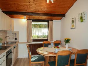 kuchnia ze stołem i krzesłami oraz oknem w obiekcie Holiday Home Robinson by Interhome w mieście Machtlos
