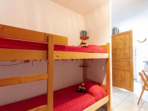 um quarto com 2 beliches e lençóis vermelhos em Apartment Plein Soleil-1 by Interhome em La Toussuire