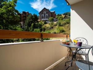 d'un balcon avec une table et une vue sur un bâtiment. dans l'établissement Apartment Chalets du Soleil-21 by Interhome, à Les Deux Alpes