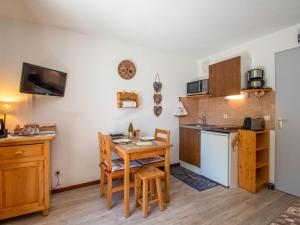 a kitchen with a table and a small kitchen with a table and chairs at Apartment Chalets du Soleil-21 by Interhome in Les Deux Alpes