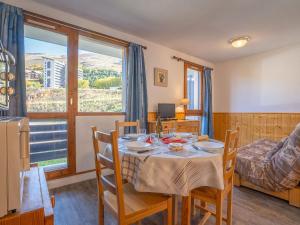 een eetkamer met een tafel en stoelen en een raam bij Apartment Sarvan 315 by Interhome in Les Menuires