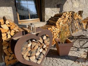 une pile de bois à côté d'une pile de bois de feu dans l'établissement Apartment Kühbeck-2 by Interhome, à Bischofsmais
