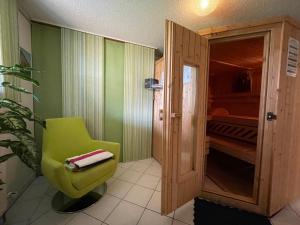 a bathroom with a green chair in a room at Apartment Kühbeck-2 by Interhome in Bischofsmais