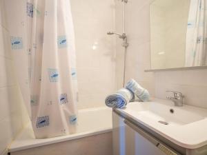 a bathroom with a shower curtain and a sink at Apartment Le Sarvan-9 by Interhome in Les Menuires