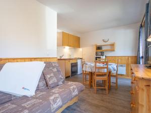 a room with a bed and a kitchen with a table at Apartment Le Sarvan-9 by Interhome in Les Menuires