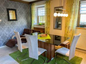 a dining room with a glass table and chairs at Apartment Kühbeck-2 by Interhome in Bischofsmais +20 photos