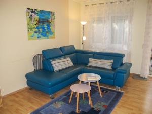 ein Wohnzimmer mit einem blauen Sofa und einem Tisch in der Unterkunft Holiday Home Lenzer Höh-4 by Interhome in Lenz