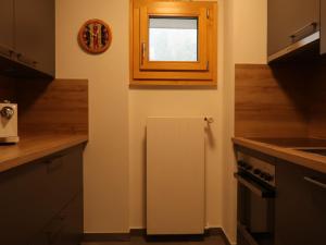 a kitchen with a small window and a white refrigerator at Apartment Rosablanche A21 by Interhome in Siviez