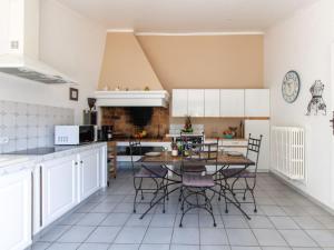 マザンにあるHoliday Home Les Amandiers by Interhomeの白いキャビネットとテーブルと椅子のあるキッチン