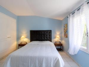ein Schlafzimmer mit einem Bett mit einem schwarzen Kopfteil und zwei Lampen in der Unterkunft Holiday Home Les Amandiers - MZN100 by Interhome in Mazan