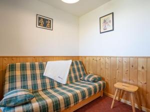 - une chambre avec un canapé et un tabouret dans l'établissement Apartment Le Sarvan-10 by Interhome, aux Menuires
