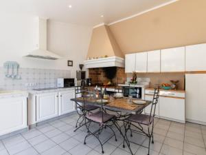 マザンにあるHoliday Home Les Amandiers by Interhomeの白いキャビネットとテーブルと椅子のあるキッチン +19枚の写真