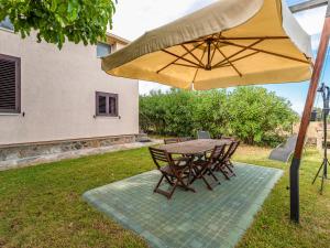 une table et des chaises sous un parapluie jaune dans l'établissement Apartment Varetto - CTN213 by Interhome, à Cervione