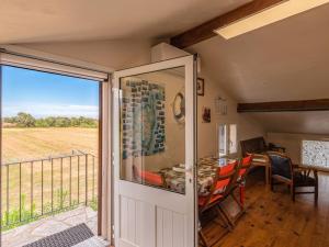 a door leading to a balcony with a table and chairs at Apartment Villa Volpajola by Interhome in Cervione