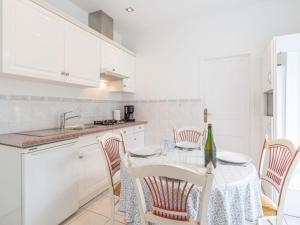 cocina blanca con mesa con sillas y fregadero en Apartment Le Chalet by Interhome, en Cabourg