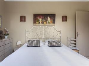 a bedroom with a large white bed with two pillows at Holiday Home Le Cèdre - MBE101 by Interhome in Ménerbes