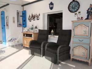 une chambre avec deux chaises, une commode et une horloge dans l'établissement Holiday Home Kerludu by Interhome, à Kerloch