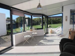 a patio with glass doors and a table and chairs at Holiday Home Kerludu by Interhome in Kerloch