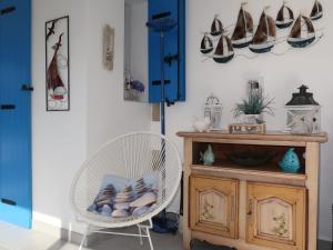 a room with a white chair and a table with shoes on the wall at Holiday Home Kerludu by Interhome in Kerloch +40 photos