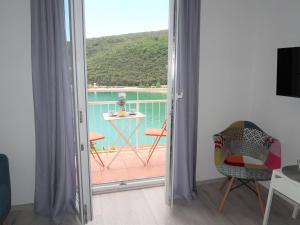 a room with a door open to a balcony with a table at Apartment Boris - RAC160 by Interhome in Raša