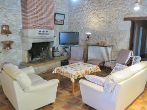 a living room with white chairs and a fireplace at Holiday Home La Raze by Interhome in Bonneville-et-Saint-Avit-de-Fumadières