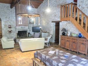 a living room with a staircase and a couch and a table at Holiday Home La Raze by Interhome in Bonneville-et-Saint-Avit-de-Fumadières