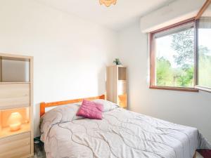a bedroom with a bed with a pink pillow on it at Apartment Les Pins Ensoleilles-7 by Interhome in Sainte-Maxime