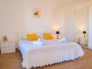 a bedroom with a large white bed with orange pillows at Apartment Marija-1 by Interhome in Vrbnik +12 photos