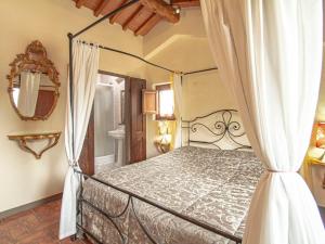 1 dormitorio con cama con dosel y espejo en Holiday Home Badia a Passignano by Interhome, en Badia A Passignano