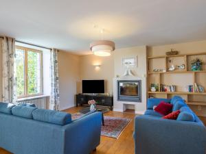 sala de estar con 2 sofás azules y TV en Holiday Home Balade Océane - TGC119 by Interhome, en Trégunc