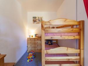 a bedroom with two bunk beds and a dresser at Studio Vostok Zodiaque-15 by Interhome in Le Corbier