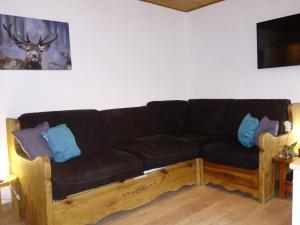 a black couch with blue pillows in a living room at Apartment Le Sérac-5 by Interhome in Val Thorens