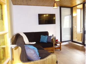a living room with a couch and a tv on the wall at Apartment Le Sérac-5 by Interhome in Val Thorens