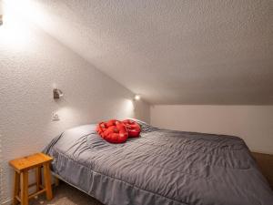 una camera da letto con un letto con cuscini rossi di Apartment Les Asters-32 by Interhome a Les Menuires