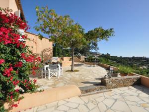 a patio with a table and chairs and flowers at Villa Mare E Sole by Interhome in Cavalaire-sur-Mer