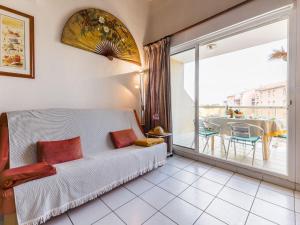 1 Schlafzimmer mit einem Bett und einem Balkon mit einem Tisch in der Unterkunft Apartment Cosy Coast - SMZ100 by Interhome in Sainte-Marie-Plage