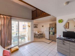 ein Wohnzimmer mit einem großen Fenster und eine Küche in der Unterkunft Apartment Cosy Coast - SMZ100 by Interhome in Sainte-Marie-Plage