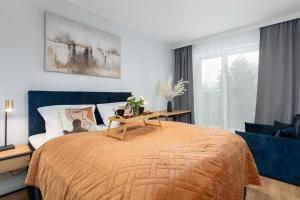 a bedroom with a bed with a table on it at Lux Wellness Resort & SPA Apartments by the River by Renters Prestige in Dziwnów