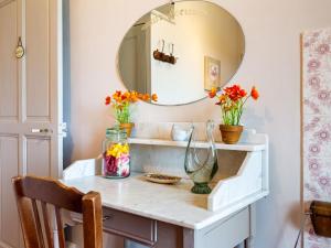 a bathroom vanity with a mirror and flowers on it at Holiday Home L'Olivier - MBE102 by Interhome in Ménerbes