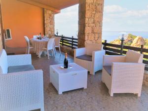 un patio con mesa y sillas y una botella de vino en Villa Gatti by Interhome, en Costa Paradiso