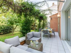 a patio with two couches and a table on a patio at Holiday Home Les Rives du Golf 3 by Interhome in Roquebrune-sur-Argens