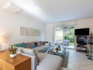 a living room with a couch and a tv at Holiday Home Les Rives du Golf 3 by Interhome in Roquebrune-sur-Argens