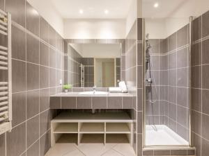 W łazience znajduje się umywalka, wanna i lustro. w obiekcie Holiday Home Les Rives du Golf 3 by Interhome w mieście Roquebrune-sur Argens