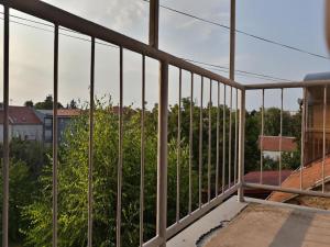 d'un balcon avec vue sur les arbres et les bâtiments. dans l'établissement Apartman Slavonija, à Osijek