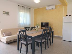 a dining room with a table and chairs and a couch at Holiday Home Fortica - LBN330 by Interhome in Nedeščina