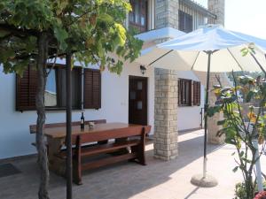 un banc et un parasol à côté d'un bâtiment dans l'établissement Holiday Home Fortica - LBN330 by Interhome, à Nedeščina