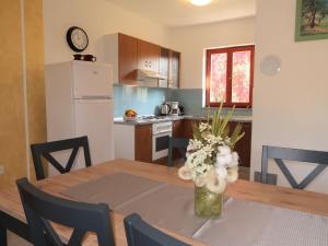 eine Küche mit einem Tisch mit einer Vase mit Blumen darauf in der Unterkunft Holiday Home Fortica by Interhome in Nedeščina + 35 Fotos