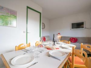 a dining room table with plates and glasses on it at Apartment Nécou-1 by Interhome in Les Menuires